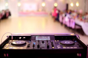 A DJ turntable with an empty dance floor in the background