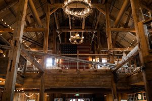 Chandeliers hang from high wood beamed ceiling at the Barn on Pemi, one of the best wedding venues in NH.