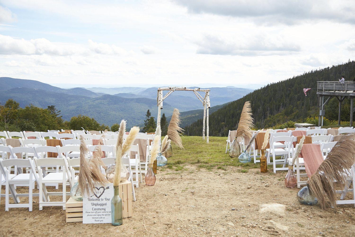 Rows of white chairs are set for a wedding ceremony on top of a mountain in NH.