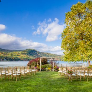 A wedding arch and rows of chairs are set up for a wedding on a sunny day at Lake Morey Resort