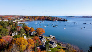 Boats sit in the bay, surrounded by houses in Kennebunk, ME on a sunny fall day